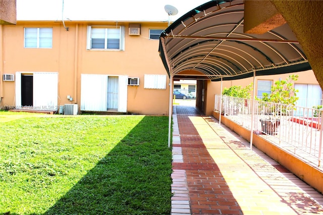 1154 W 35th St Unit 221, Hialeah, FL 33012 - rear view of house featuring stucco siding, a lawn, and a wall unit AC