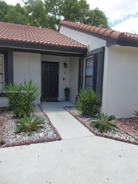 15299 SW 45th Ter Unit G-63, Miami, FL 33185 - view of exterior entry with stucco siding and a tiled roof
