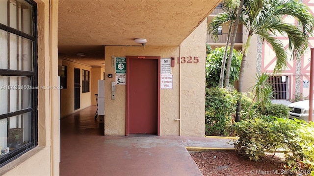 1325 W 68th St Unit 214, Hialeah, FL 33014 - doorway to property featuring stucco siding and elevator