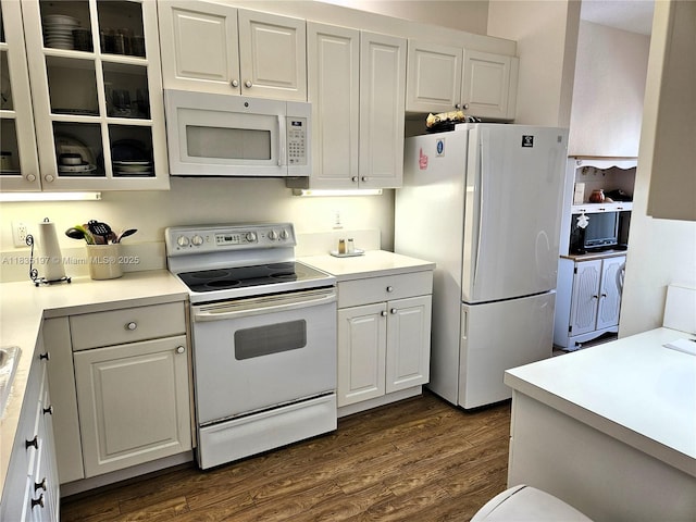 7611 Southampton Ter Unit 102, Tamarac, FL 33321 - kitchen featuring white appliances, dark wood-type flooring, white cabinets, and glass insert cabinets