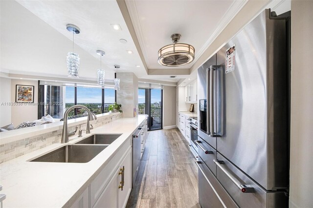 4000 Towerside Ter Unit 1507, Miami, FL 33138 - kitchen with stainless steel appliances, light wood finished floors, white cabinetry, light countertops, and ornamental molding