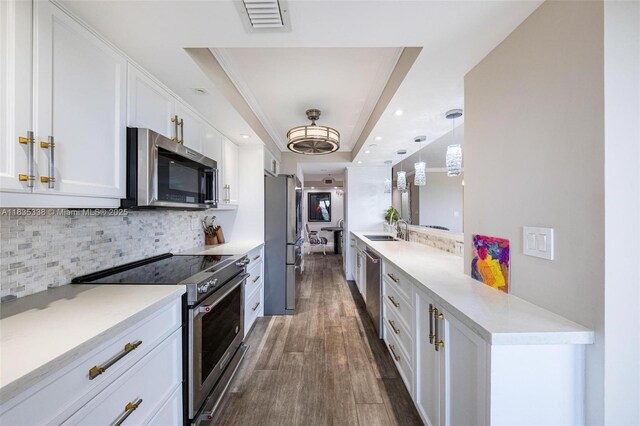 4000 Towerside Ter Unit 1507, Miami, FL 33138 - kitchen with appliances with stainless steel finishes, a tray ceiling, white cabinets, decorative backsplash, and dark wood-style flooring