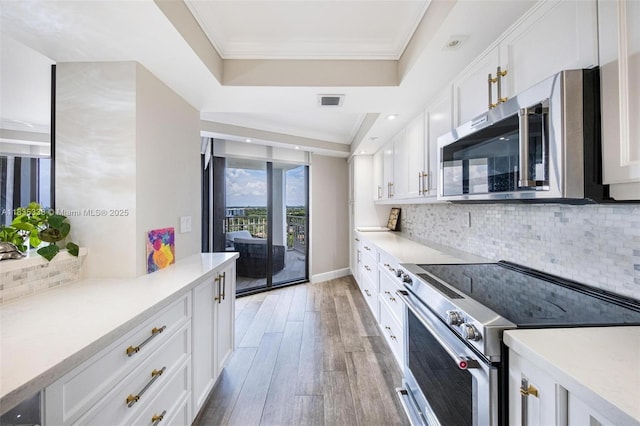4000 Towerside Ter Unit 1507, Miami, FL 33138 - kitchen featuring appliances with stainless steel finishes, light wood-type flooring, white cabinetry, light countertops, and crown molding