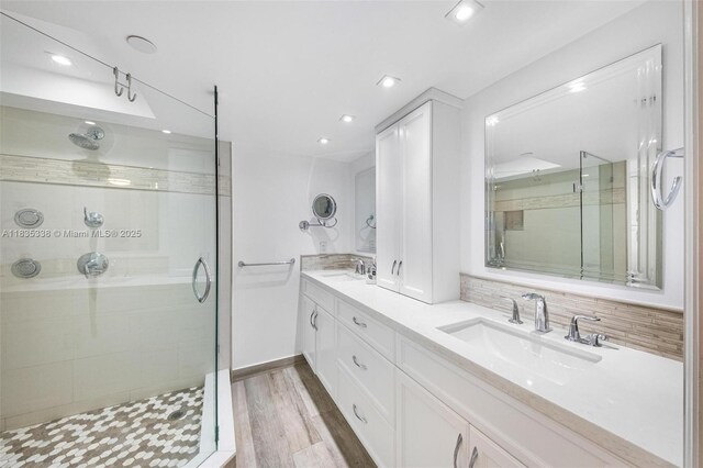4000 Towerside Ter Unit 1507, Miami, FL 33138 - bathroom with a shower stall, double vanity, wood finished floors, and recessed lighting