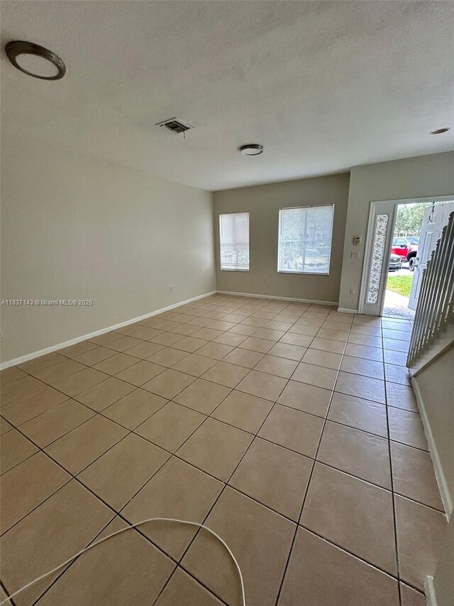 8297 SW 25th Ct Unit 101, Miramar, FL 33025 - empty room featuring plenty of natural light, light tile patterned flooring, and a textured ceiling