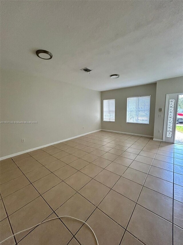8297 SW 25th Ct Unit 101, Miramar, FL 33025 - empty room featuring light tile patterned flooring, plenty of natural light, and a textured ceiling