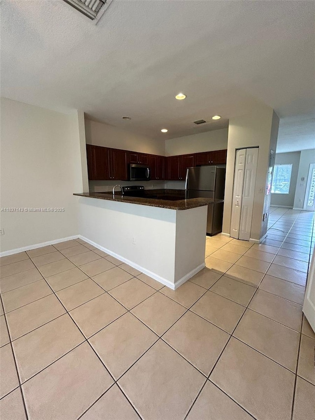 8297 SW 25th Ct Unit 101, Miramar, FL 33025 - kitchen featuring stainless steel appliances, dark countertops, light tile patterned flooring, a peninsula, and recessed lighting