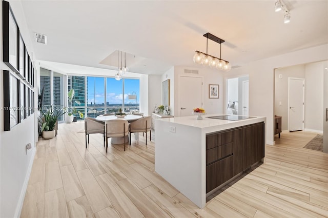 851 NE 1st Ave Unit 2809, Miami, FL 33132 - kitchen with expansive windows, an island with sink, pendant lighting, light countertops, and black electric stovetop