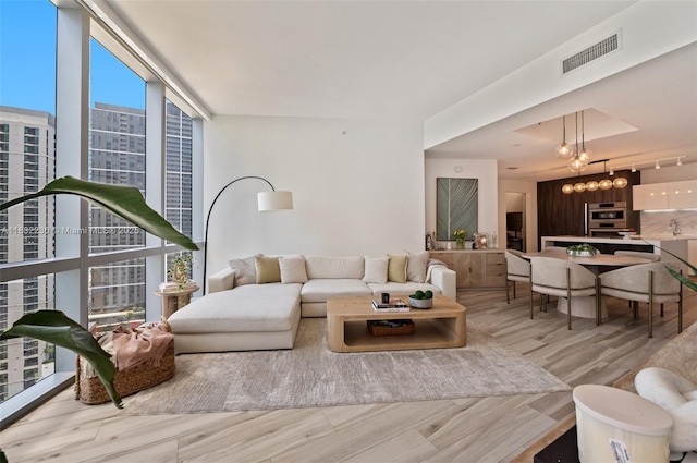 851 NE 1st Ave Unit 2809, Miami, FL 33132 - living room with wood finished floors, floor to ceiling windows, a chandelier, and a city view
