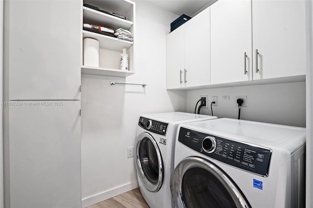 851 NE 1st Ave Unit 2809, Miami, FL 33132 - laundry room with cabinet space, washing machine and clothes dryer, and light wood finished floors