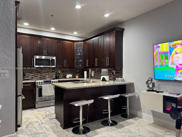4301 SW 160th Ave Unit 215, Miramar, FL 33027 - kitchen with stainless steel appliances, backsplash, light marble finish floors, a peninsula, and recessed lighting