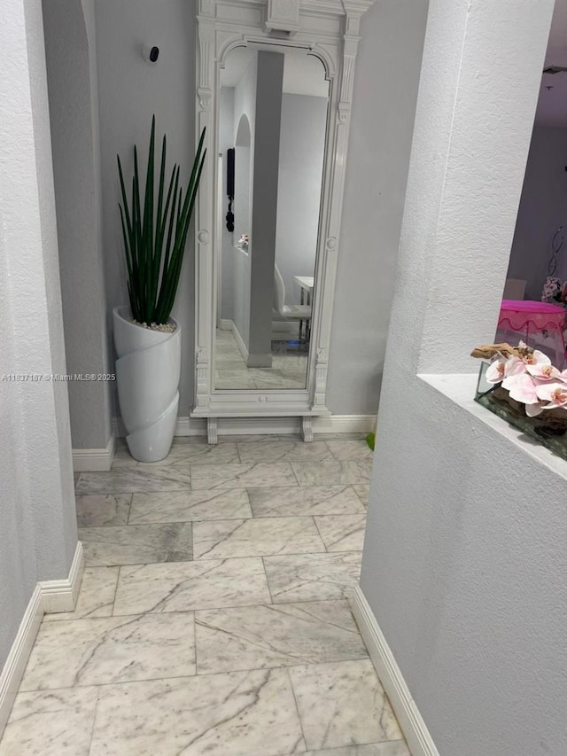 4301 SW 160th Ave Unit 215, Miramar, FL 33027 - hallway featuring arched walkways, marble look tile flooring, and a textured wall