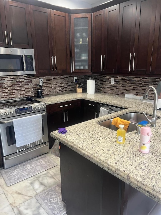 4301 SW 160th Ave Unit 215, Miramar, FL 33027 - kitchen featuring appliances with stainless steel finishes, light stone countertops, decorative backsplash, glass insert cabinets, and dark brown cabinets