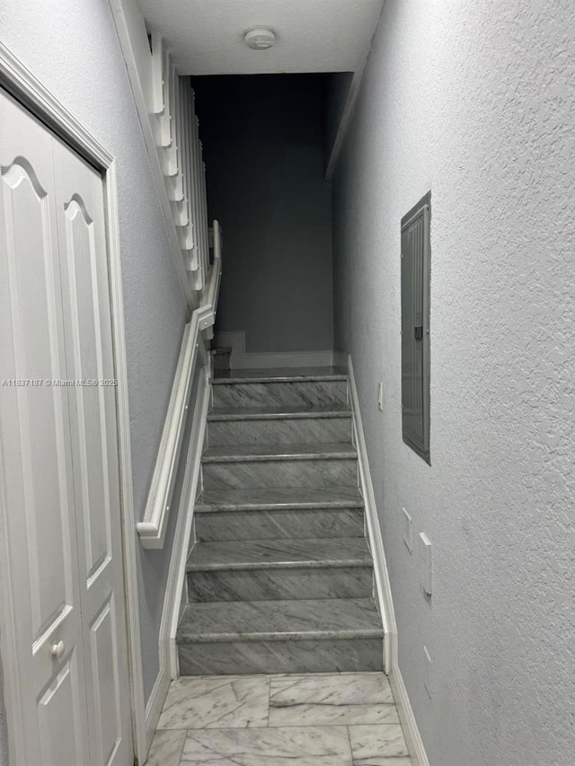 4301 SW 160th Ave Unit 215, Miramar, FL 33027 - stairs featuring marble look tile flooring, a textured wall, and electric panel