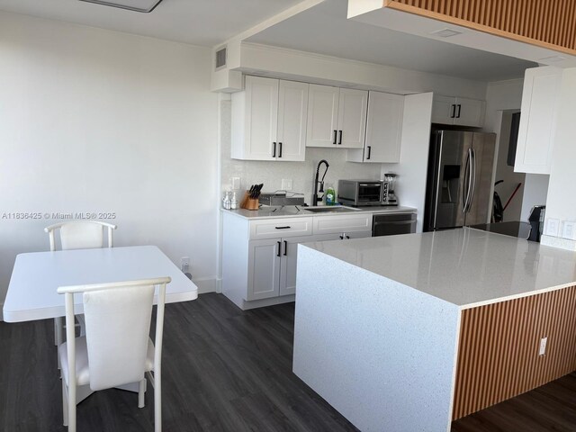 3589 S Ocean Blvd Unit 914, South Palm Beach, FL 33480 - kitchen featuring stainless steel fridge, dark wood-type flooring, and white cabinetry