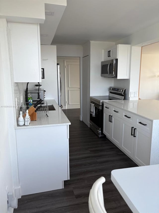 3589 S Ocean Blvd Unit 914, South Palm Beach, FL 33480 - kitchen with appliances with stainless steel finishes, dark wood finished floors, light countertops, and white cabinets
