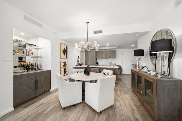 801 S Miami Ave Unit 1210, Miami, FL 33130 - dining space featuring light wood-style flooring, recessed lighting, a chandelier, and bar area