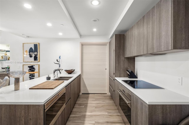 801 S Miami Ave Unit 1210, Miami, FL 33130 - kitchen featuring modern cabinets, black electric stovetop, oven, a peninsula, and light countertops