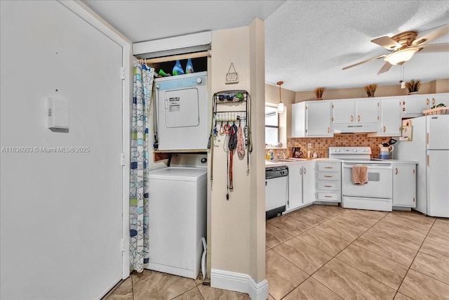 6555 W Broward Blvd Unit 300, Plantation, FL 33317 - kitchen featuring white appliances, under cabinet range hood, estacked washer and dryer, light countertops, and white cabinets