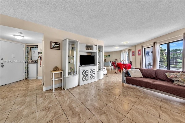 6555 W Broward Blvd Unit 300, Plantation, FL 33317 - living room with a textured ceiling, light tile patterned floors, and washer / dryer