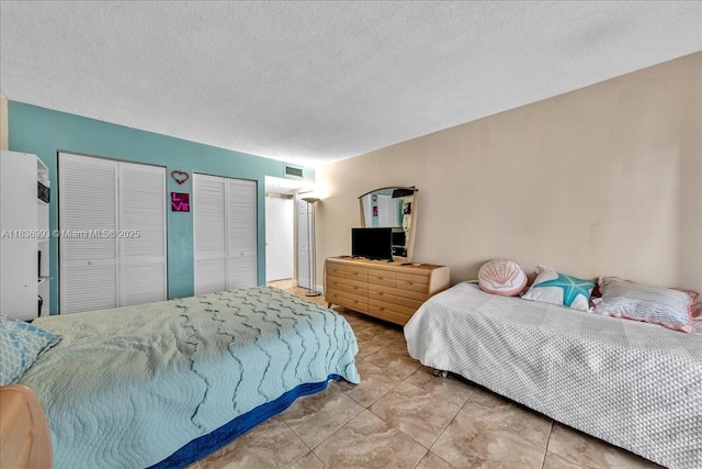 6555 W Broward Blvd Unit 300, Plantation, FL 33317 - bedroom featuring multiple closets and a textured ceiling