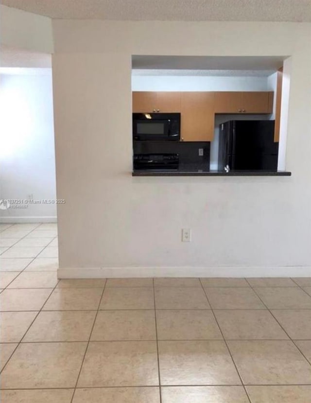 4653 NW 97 Unit 21, Doral, FL 33178 - kitchen with black appliances, light tile patterned flooring, and dark countertops