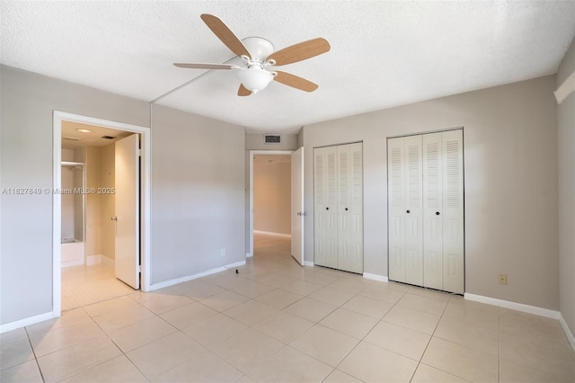 1000 SW 128th Ter Unit 312V, Pembroke Pines, FL 33027 - unfurnished bedroom featuring two closets, light tile patterned floors, a textured ceiling, and ensuite bathroom