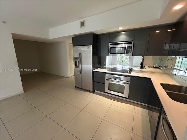 31 SE 6th St Unit 407, Miami, FL 33131 - kitchen featuring stainless steel appliances, light countertops, dark cabinetry, light tile patterned floors, and recessed lighting