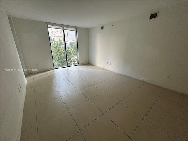31 SE 6th St Unit 407, Miami, FL 33131 - spare room featuring expansive windows and light tile patterned floors