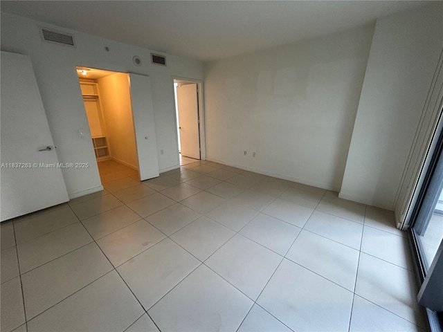 31 SE 6th St Unit 407, Miami, FL 33131 - unfurnished bedroom featuring a walk in closet and light tile patterned flooring
