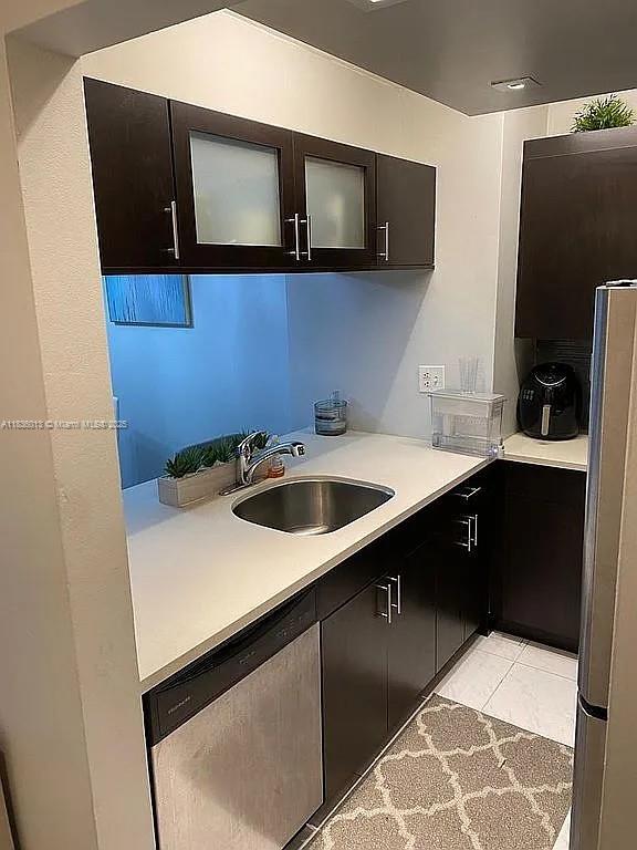 800 N Miami Ave Unit E-707, Miami, FL 33136 - kitchen with appliances with stainless steel finishes, light countertops, glass insert cabinets, and light tile patterned flooring