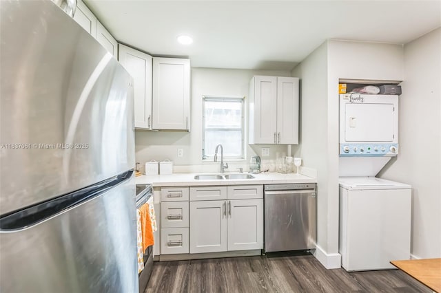 3201 NW 4th Ter Unit 80, Pompano Beach, FL 33064 - kitchen featuring stainless steel appliances, stacked washer and clothes dryer, dark wood finished floors, and light countertops