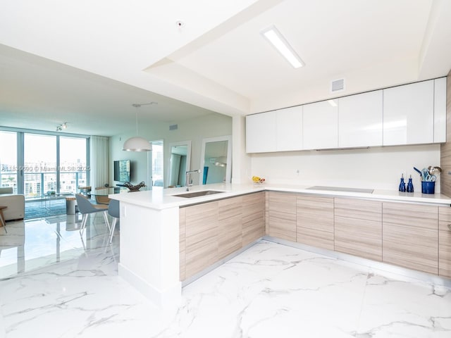 300 Sunny Isles Blvd Unit 5-1605, Sunny Isles Beach, FL 33160 - kitchen featuring modern cabinets, a peninsula, light countertops, decorative light fixtures, and expansive windows