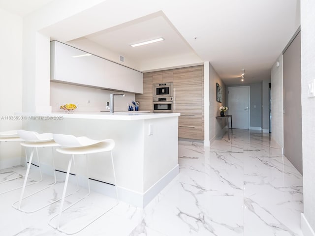 300 Sunny Isles Blvd Unit 5-1605, Sunny Isles Beach, FL 33160 - kitchen with light marble finish floors, modern cabinets, stainless steel oven, and white cabinets