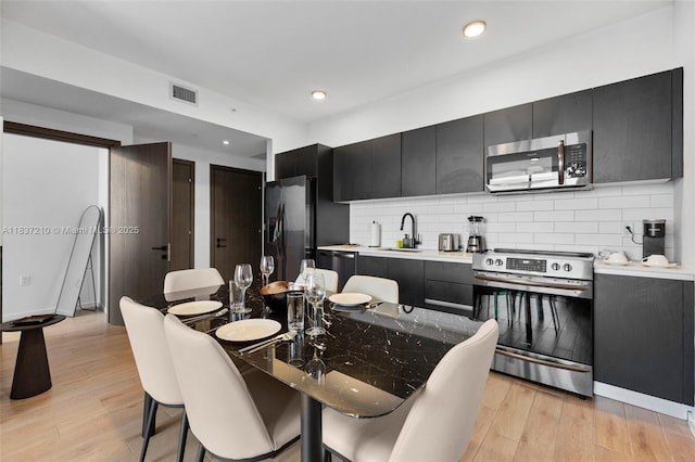 398 NE 5th St Unit 3219, Miami, FL 33132 - kitchen with stainless steel appliances, dark cabinets, light wood finished floors, and recessed lighting