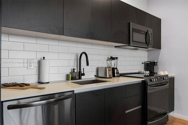 398 NE 5th St Unit 3219, Miami, FL 33132 - kitchen featuring appliances with stainless steel finishes, modern cabinets, dark cabinetry, and decorative backsplash