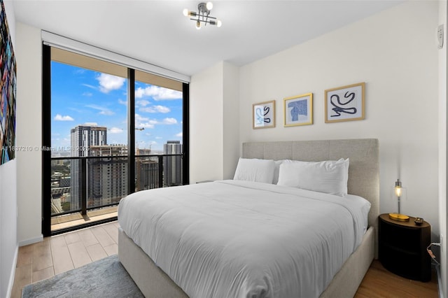 398 NE 5th St Unit 3219, Miami, FL 33132 - bedroom featuring a wall of windows, wood finished floors, and a city view