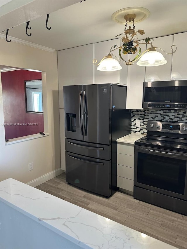 661 N University Dr Unit 1-201, Pembroke Pines, FL 33024 - kitchen with appliances with stainless steel finishes, crown molding, light wood-type flooring, decorative backsplash, and light stone countertops