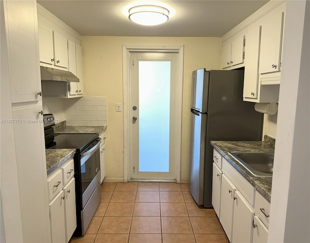 1720 Funston St Unit 111, Hollywood, FL 33020 - kitchen with appliances with stainless steel finishes, under cabinet range hood, white cabinetry, dark countertops, and light tile patterned floors