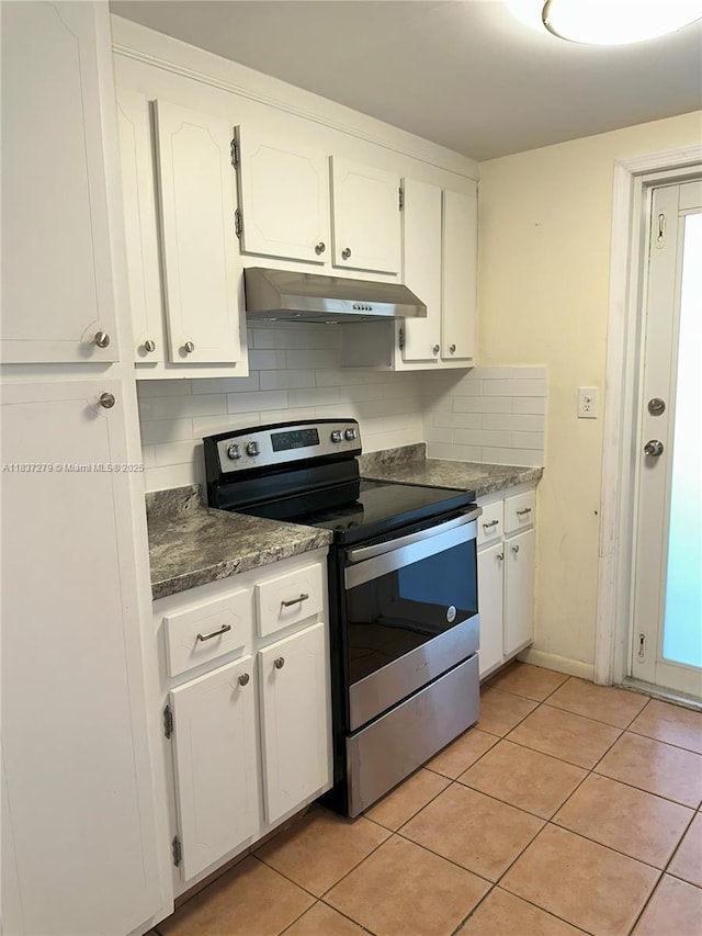 1720 Funston St Unit 111, Hollywood, FL 33020 - kitchen featuring electric range, under cabinet range hood, white cabinetry, light tile patterned floors, and tasteful backsplash