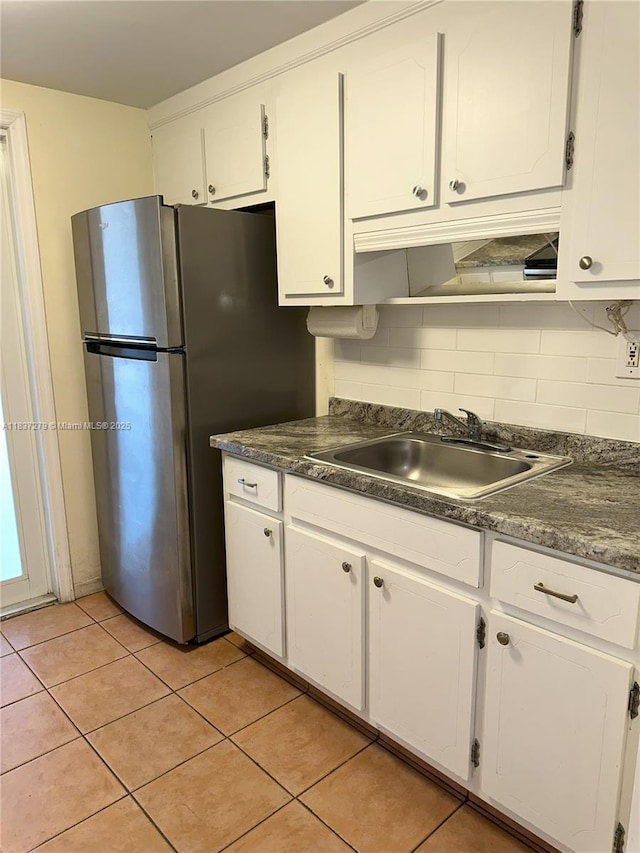 1720 Funston St Unit 111, Hollywood, FL 33020 - kitchen with white cabinets, dark countertops, and freestanding refrigerator