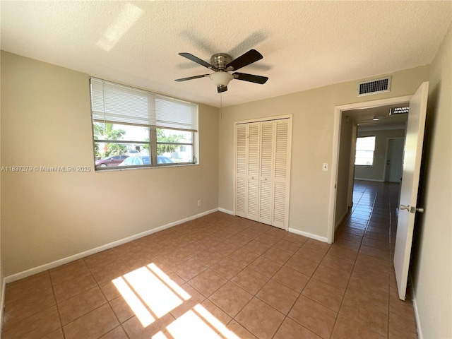 1720 Funston St Unit 111, Hollywood, FL 33020 - unfurnished bedroom with light tile patterned floors, a textured ceiling, a closet, and ceiling fan