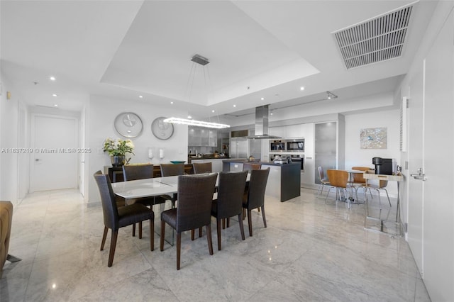 18201 Collins Ave Unit 1006, Sunny Isles Beach, FL 33160 - dining space featuring a tray ceiling, light marble finish flooring, and recessed lighting