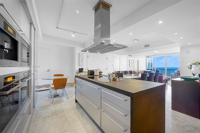 18201 Collins Ave Unit 1006, Sunny Isles Beach, FL 33160 - kitchen with island exhaust hood, oven, black electric cooktop, modern cabinets, and a center island