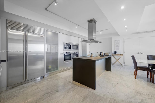 18201 Collins Ave Unit 1006, Sunny Isles Beach, FL 33160 - kitchen featuring built in appliances, island exhaust hood, modern cabinets, white cabinets, and a kitchen island
