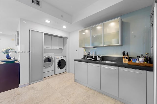 18201 Collins Ave Unit 1006, Sunny Isles Beach, FL 33160 - laundry area with washing machine and dryer, cabinet space, bar with sink, recessed lighting, and light tile patterned flooring