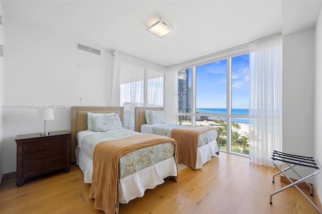 18201 Collins Ave Unit 1006, Sunny Isles Beach, FL 33160 - bedroom with expansive windows, multiple windows, light wood finished floors, and a water view