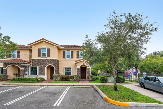 4326 Braxton Ave, West Palm Beach, FL 33417 - view of property featuring stone siding, stucco siding, uncovered parking, and a tile roof