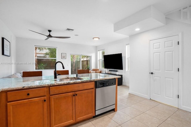 4326 Braxton Ave, West Palm Beach, FL 33417 - kitchen with stainless steel dishwasher, brown cabinetry, light stone countertops, light tile patterned flooring, and recessed lighting