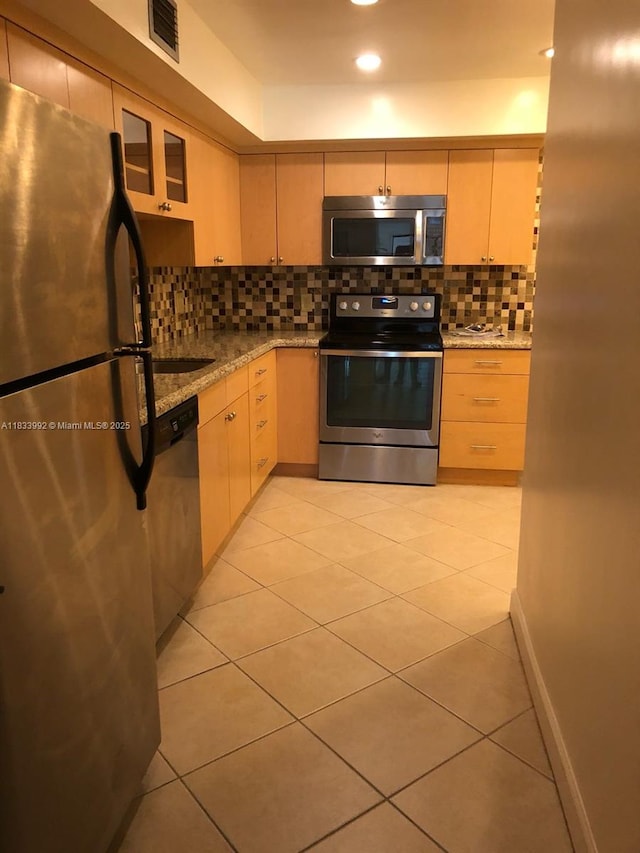 4000 N Hills Dr Unit 32, Hollywood, FL 33021 - kitchen featuring appliances with stainless steel finishes, decorative backsplash, light stone countertops, light tile patterned floors, and recessed lighting